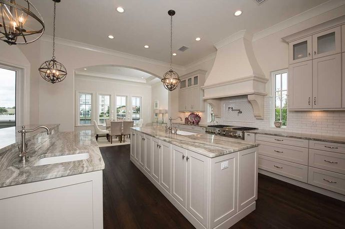 A large kitchen with white cabinets and granite counter tops.