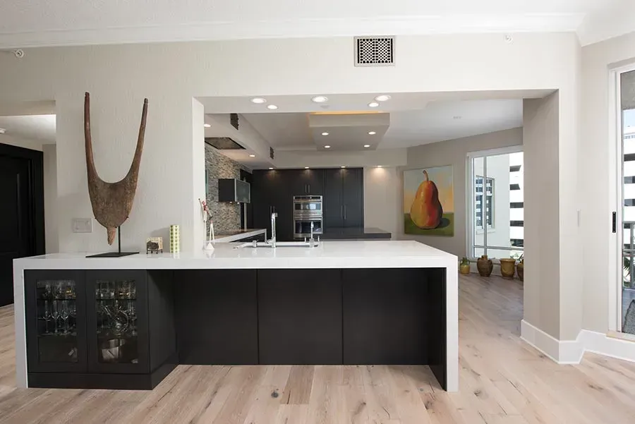A kitchen with a large island and a painting of a pear on the wall