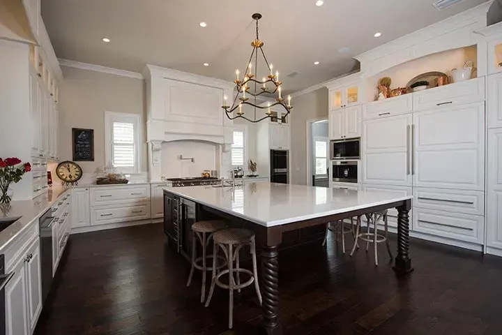 A large kitchen with white cabinets and a large island in the middle.