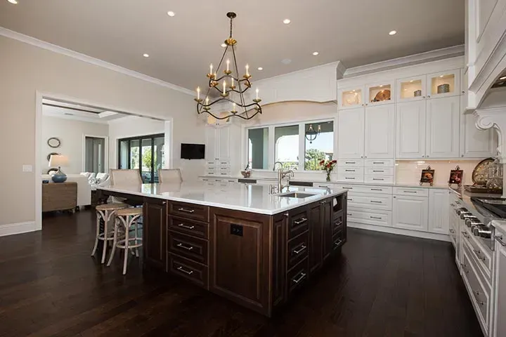 A kitchen with white cabinets and a large island in the middle.