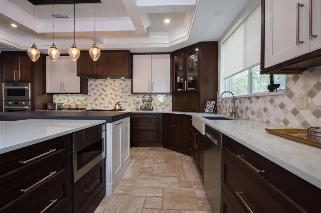 A kitchen with stainless steel appliances , wooden cabinets , and white counter tops.