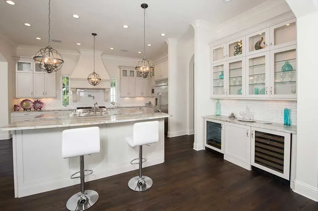 A kitchen with a large island and two bar stools.