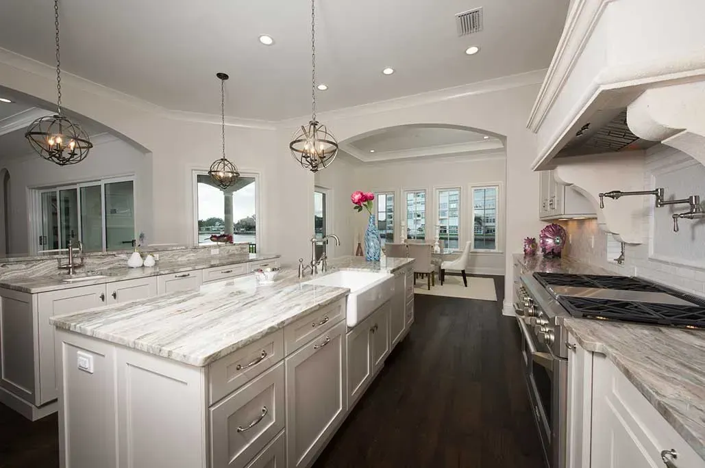 A large kitchen with white cabinets and granite counter tops.