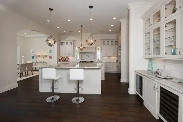 A kitchen with a large island and two bar stools.