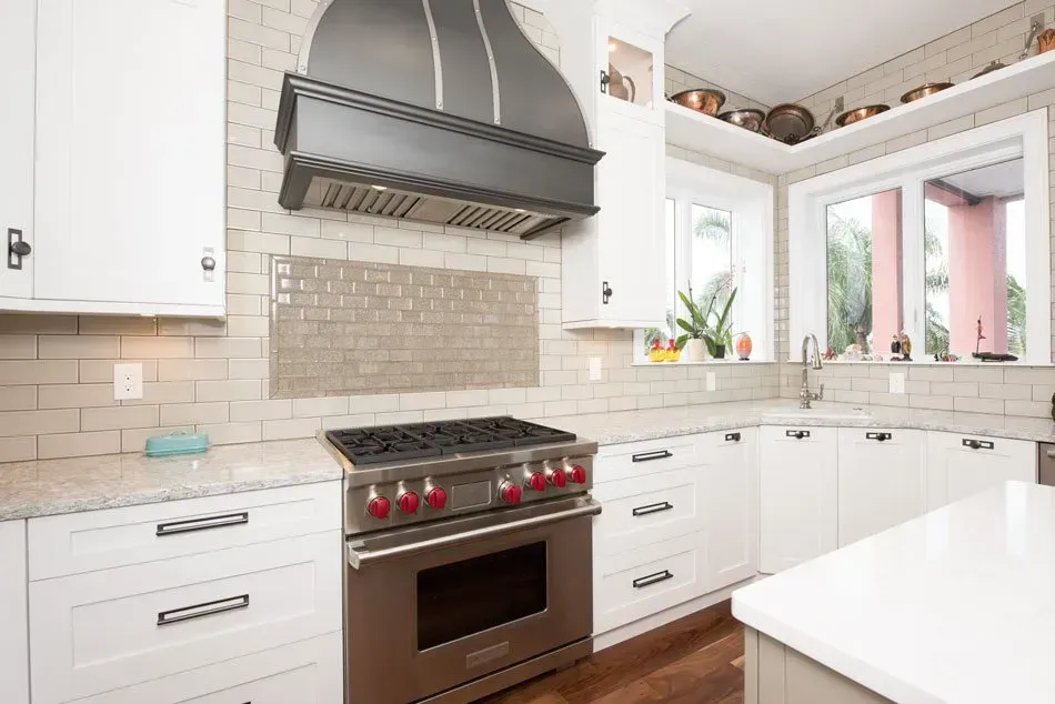 A kitchen with stainless steel appliances and white cabinets.
