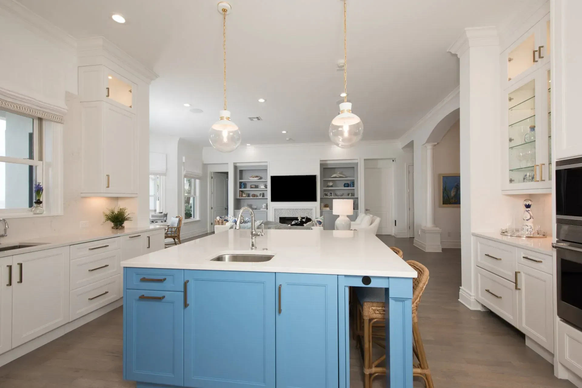 A kitchen with blue cabinets and white counter tops and a large island.