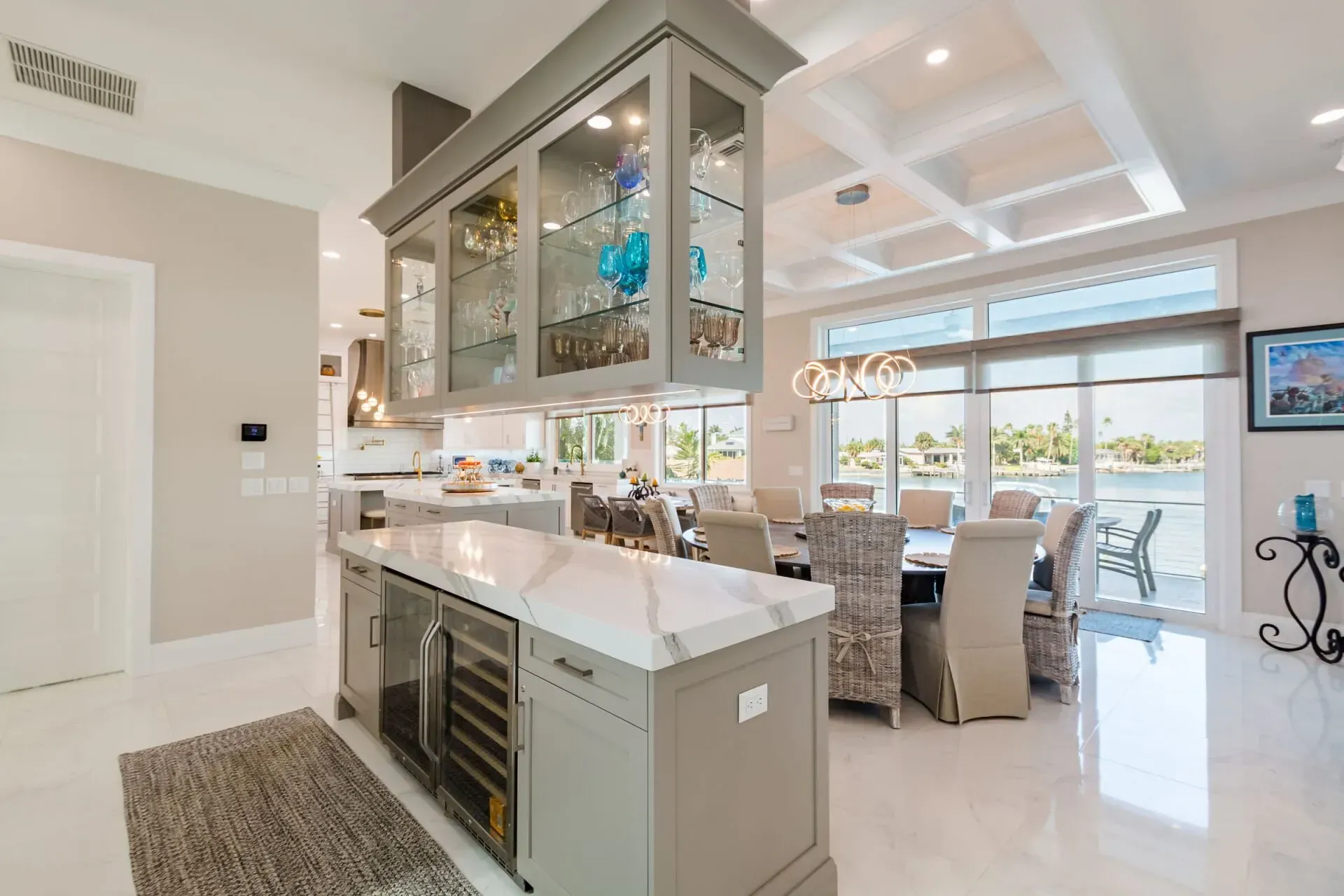 A kitchen and dining room in a house with a large island in the middle.