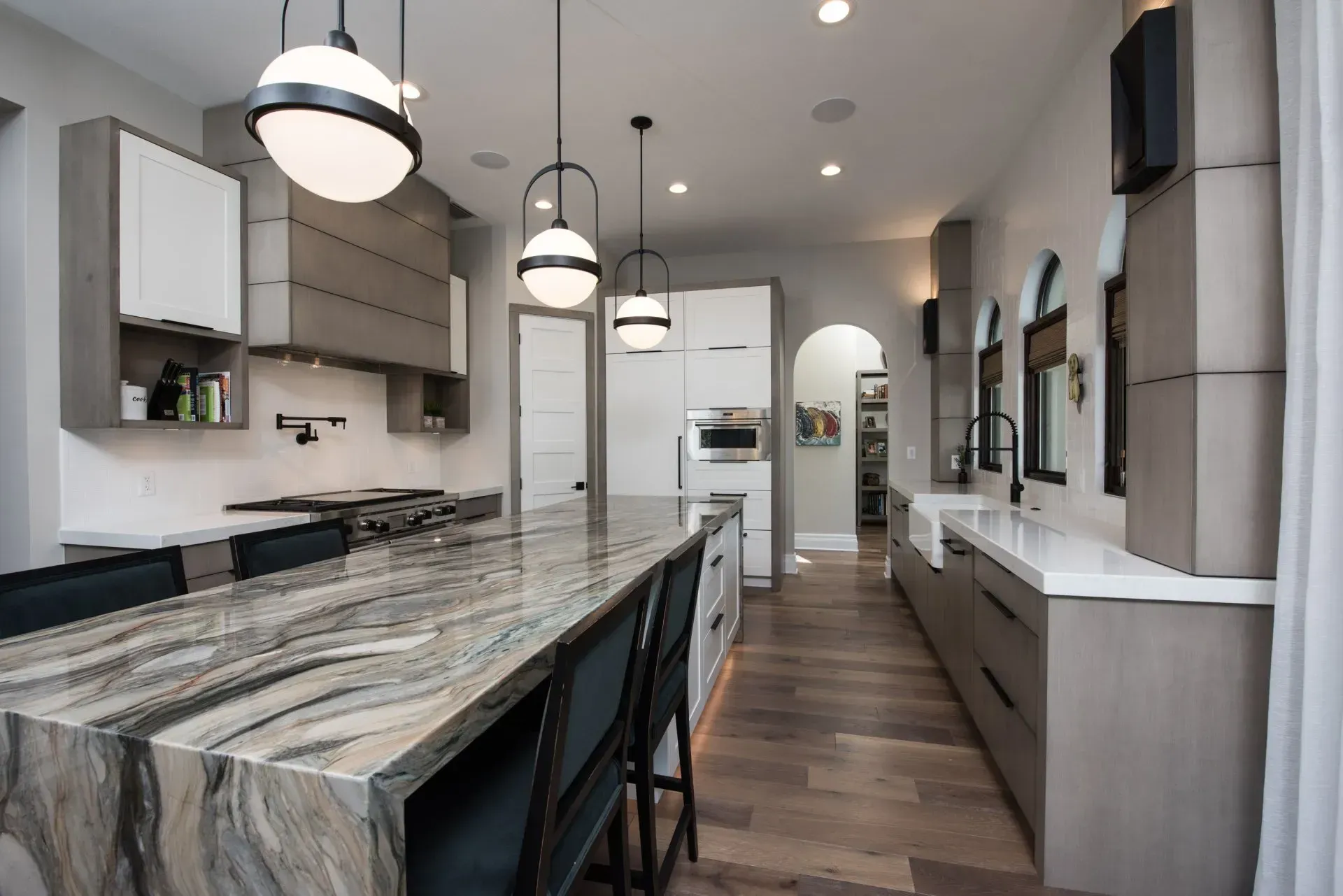 A kitchen with a large island in the middle and a marble counter top.