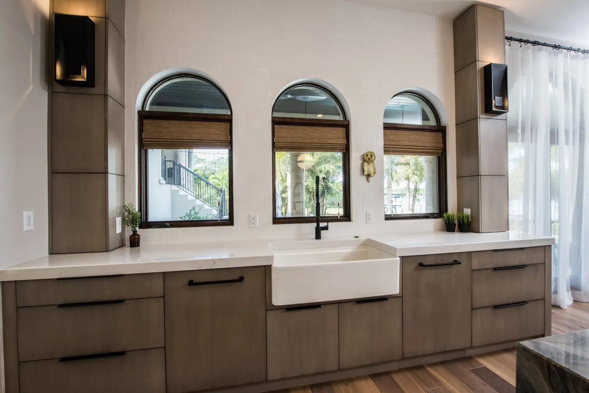 A kitchen with a sink and three arched windows