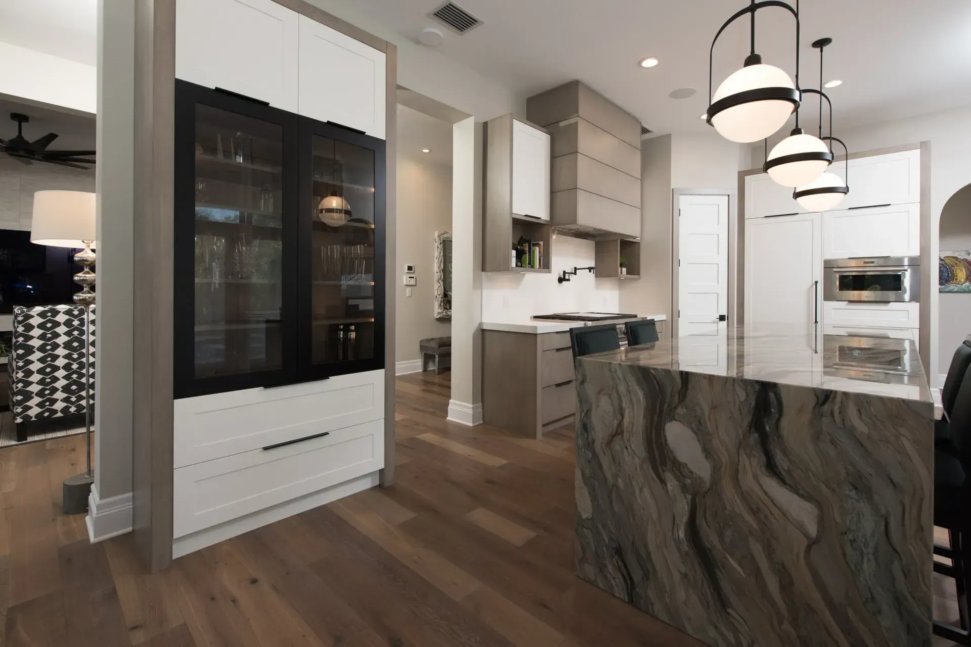 A kitchen with a large island and a marble counter top.