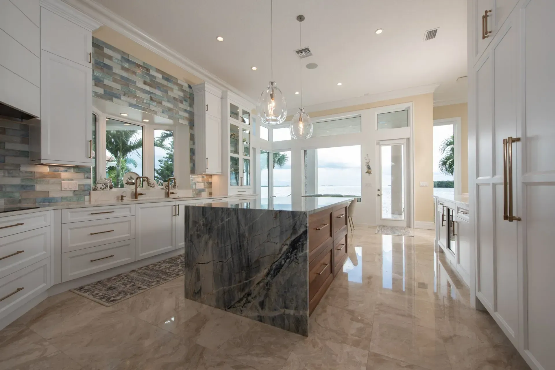 A kitchen with white cabinets and a large island in the middle.