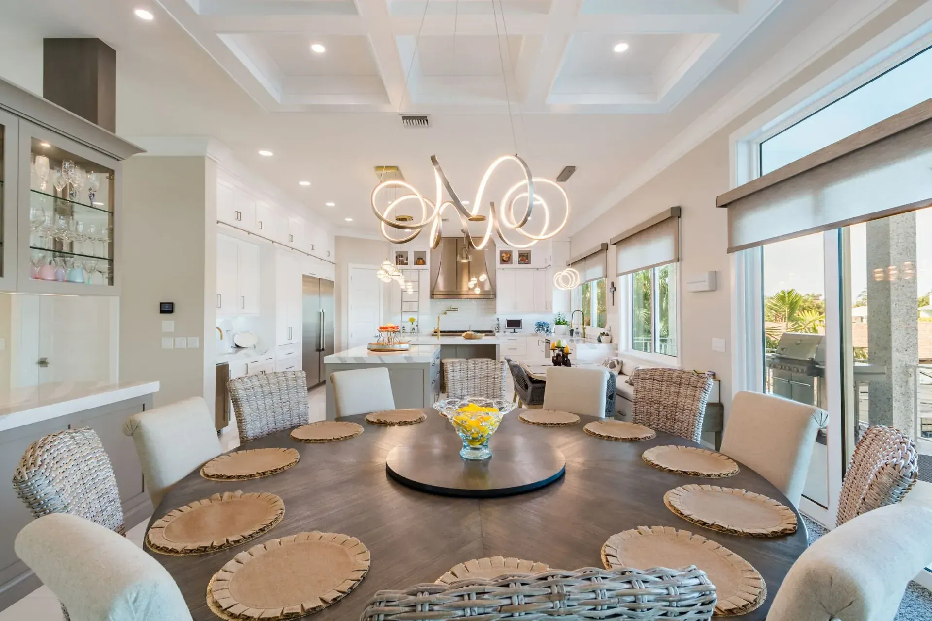 A large dining room with a round table and chairs and a chandelier.