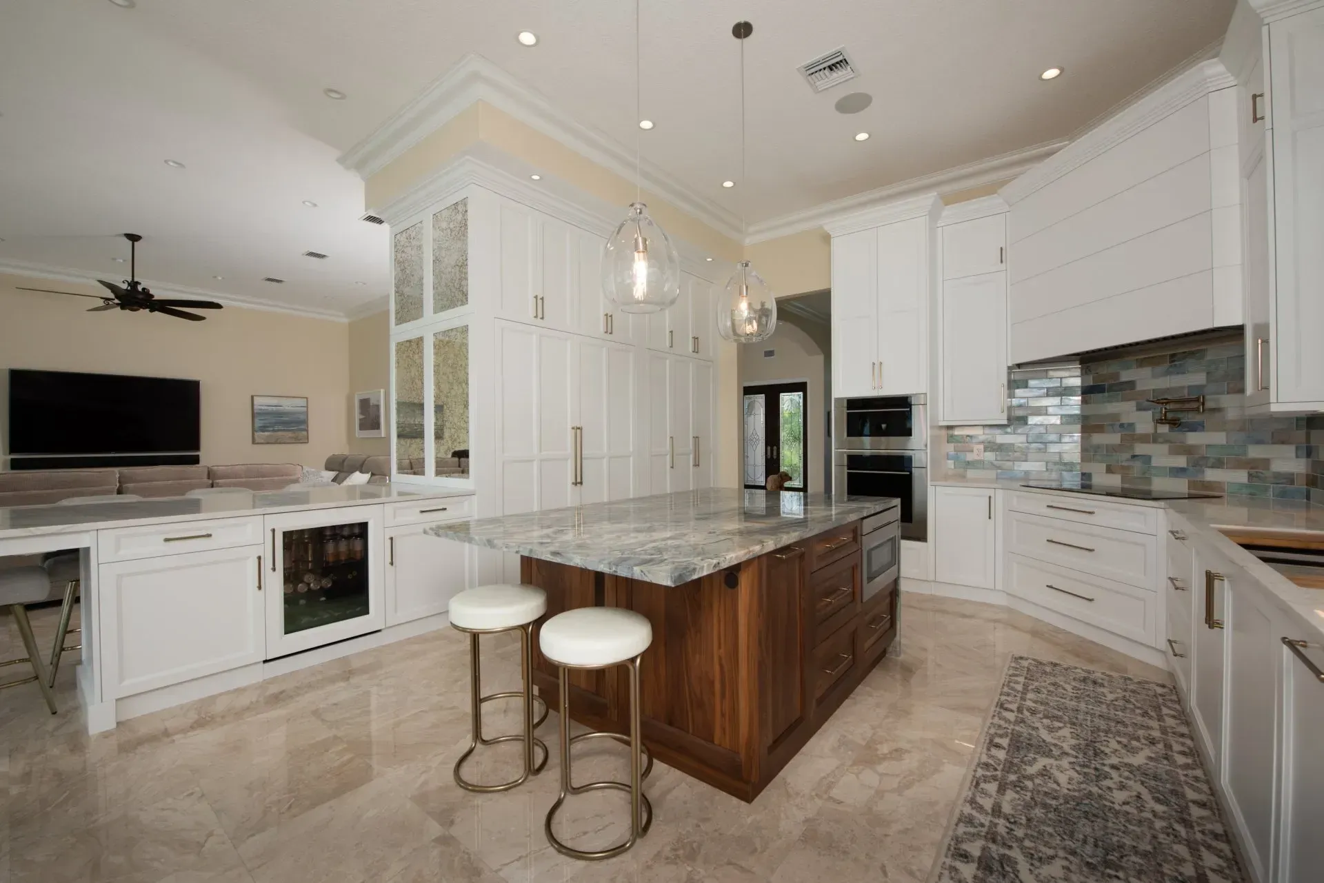 A kitchen with white cabinets and a large island in the middle