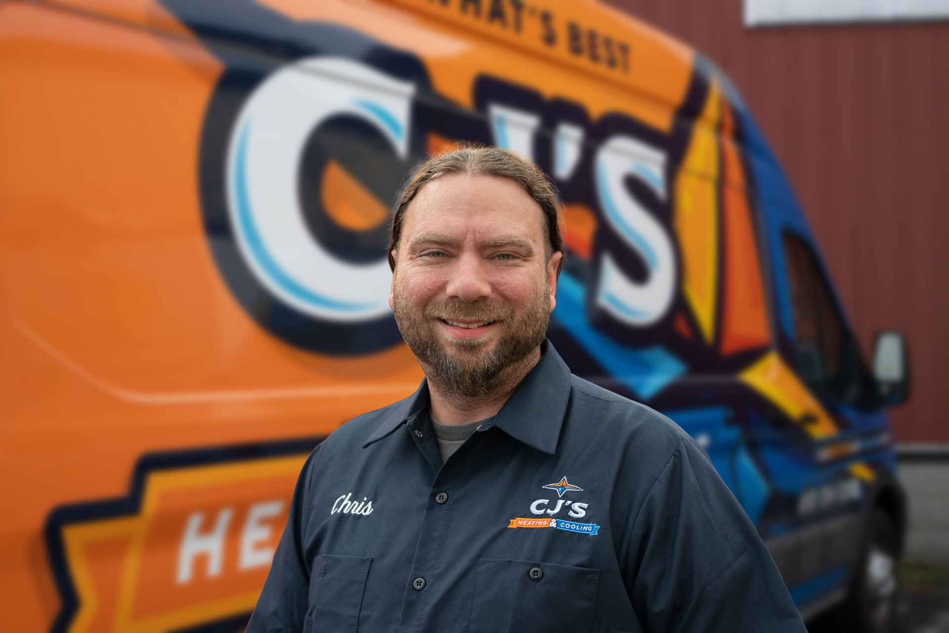 Chris from CJ's Heating and Cooling is standing in front of a van
