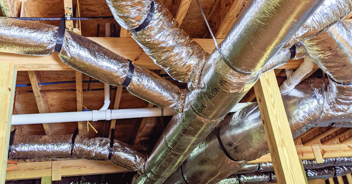 A bunch of pipes are hanging from the ceiling of a building. A bunch of pipes are hanging from the ceiling of a building.