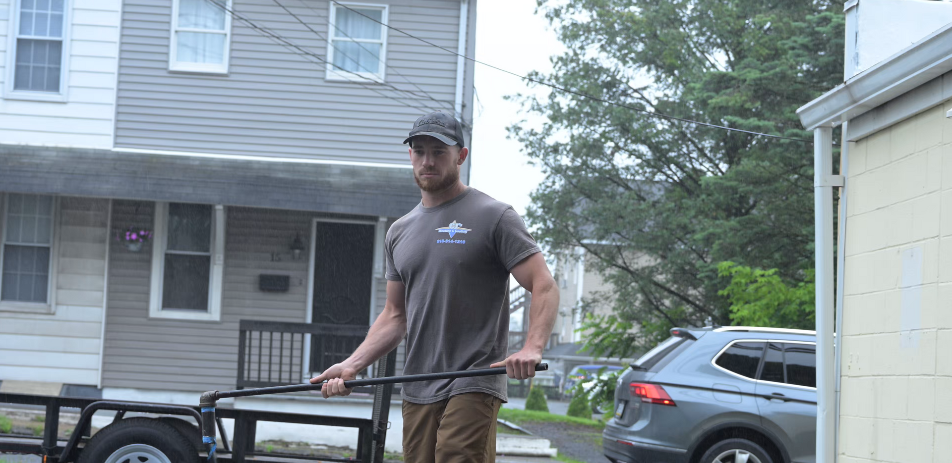 A man is pulling a trailer in front of a house.