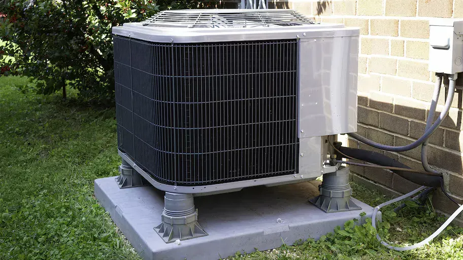 An air conditioner is sitting outside of a brick building. An air conditioner is sitting outside of a brick building.