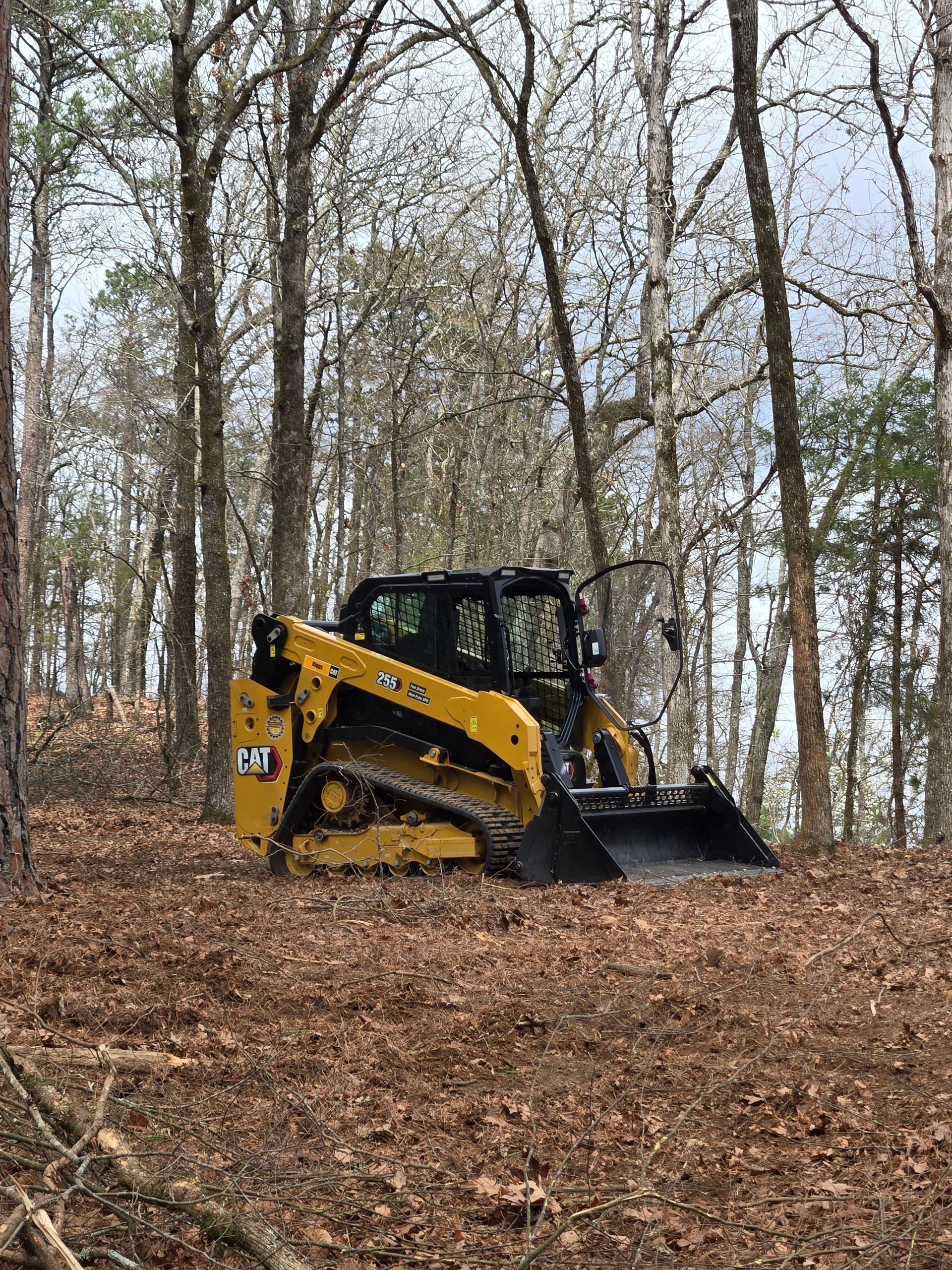 Compact skid steer loader with bucket on a muddy construction site