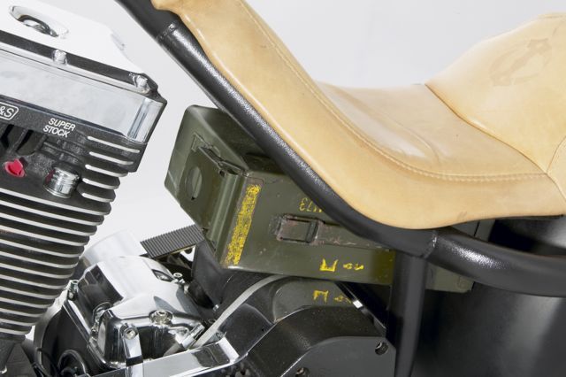 A motorcycle with a box of ammunition under the seat