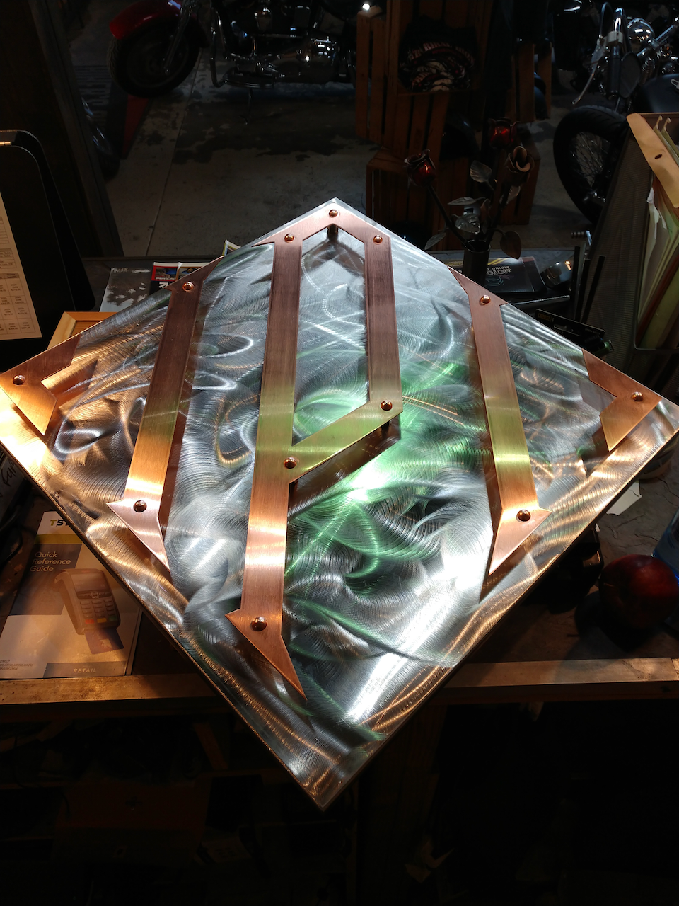A piece of metal is sitting on a table in a dark room.
