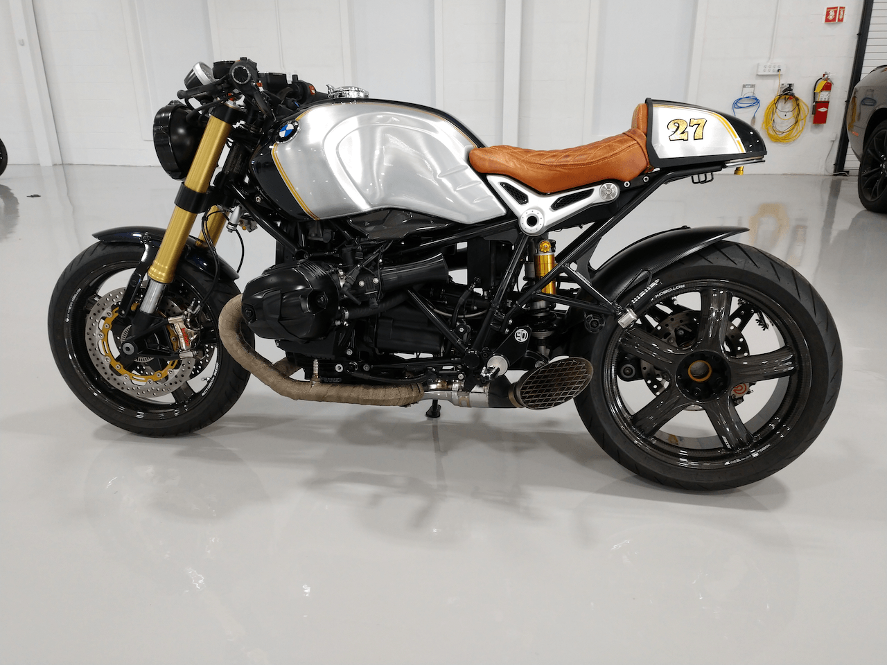 A motorcycle is parked on a concrete floor in a garage.