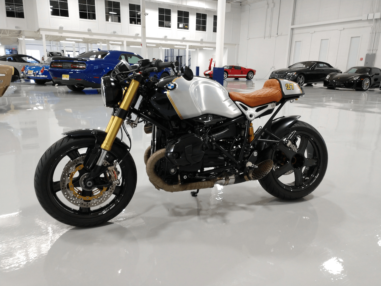 A motorcycle is parked in a garage next to cars.
