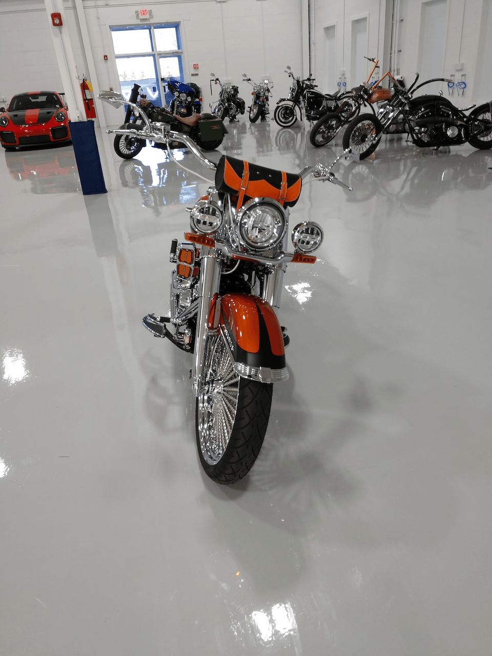 A motorcycle is parked in a garage next to other motorcycles.
