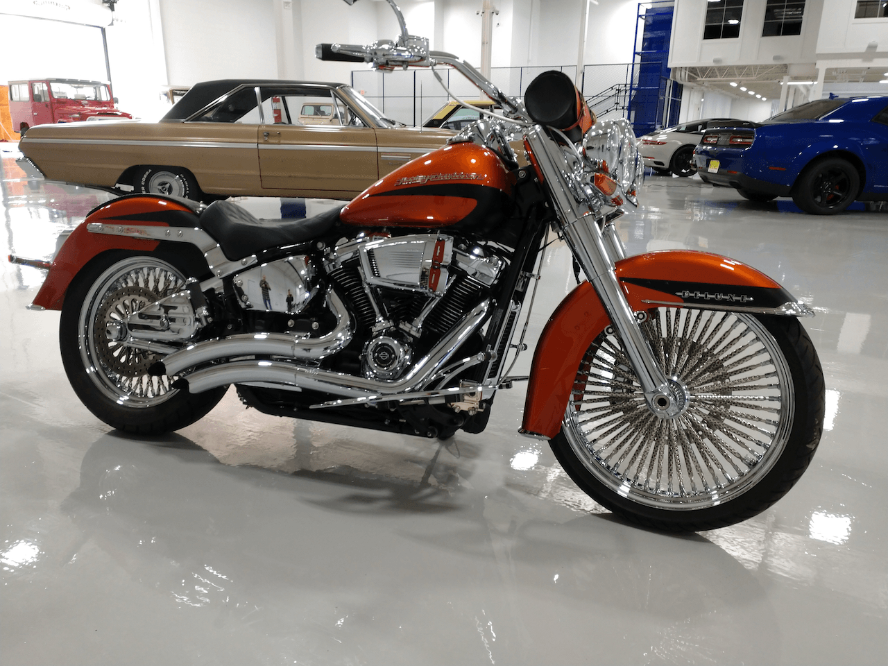 An orange harley davidson motorcycle is parked in a garage.