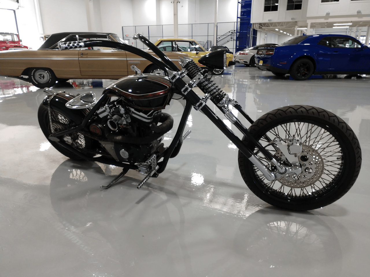 A black chopper motorcycle is parked in a garage