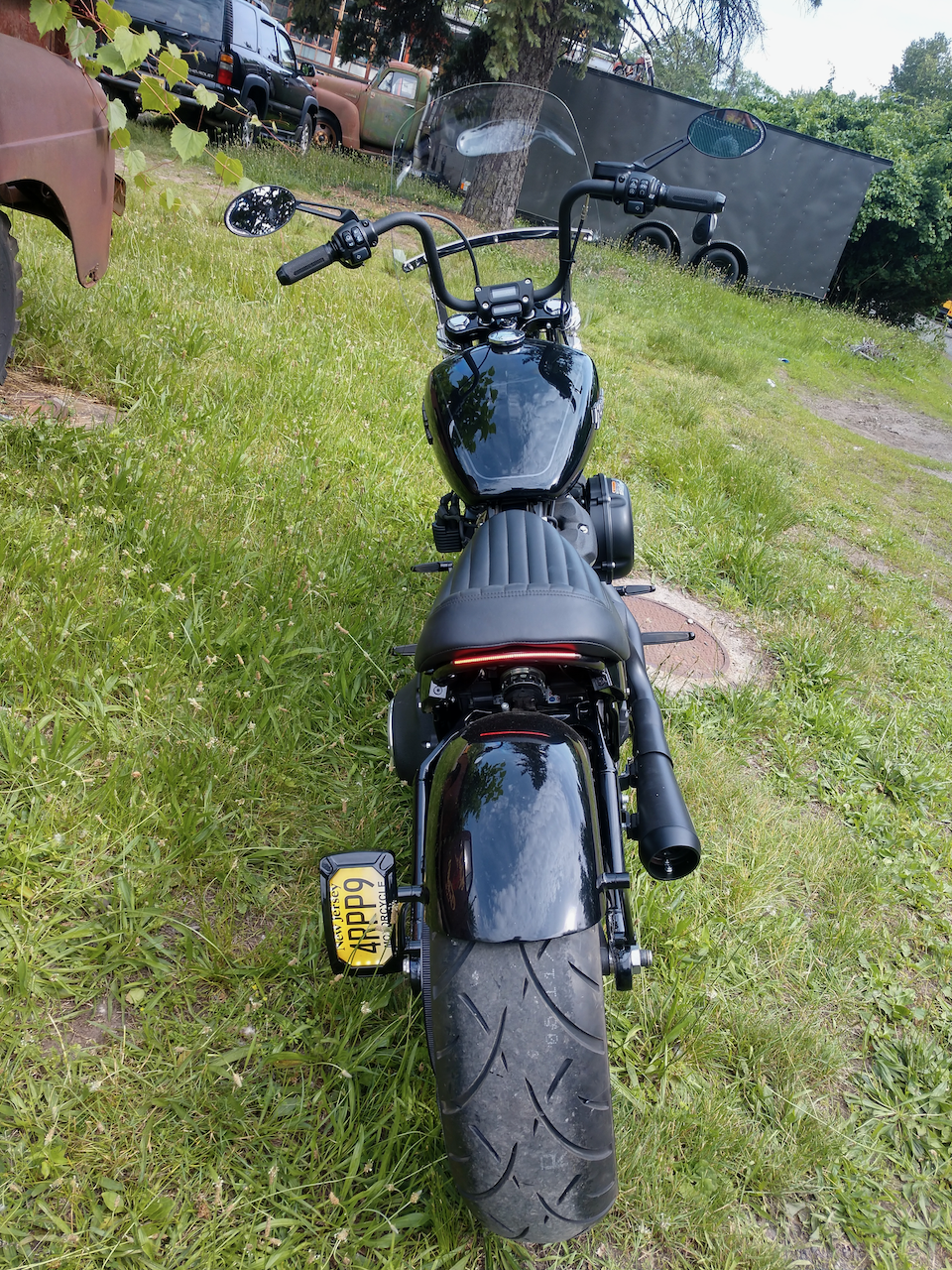 A black motorcycle is parked in a grassy field.