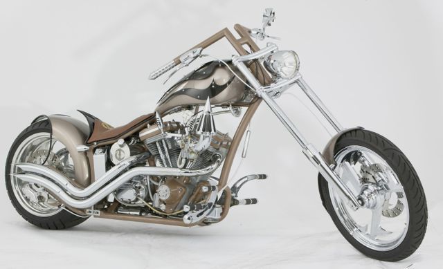 A brown and silver motorcycle is parked on a white surface