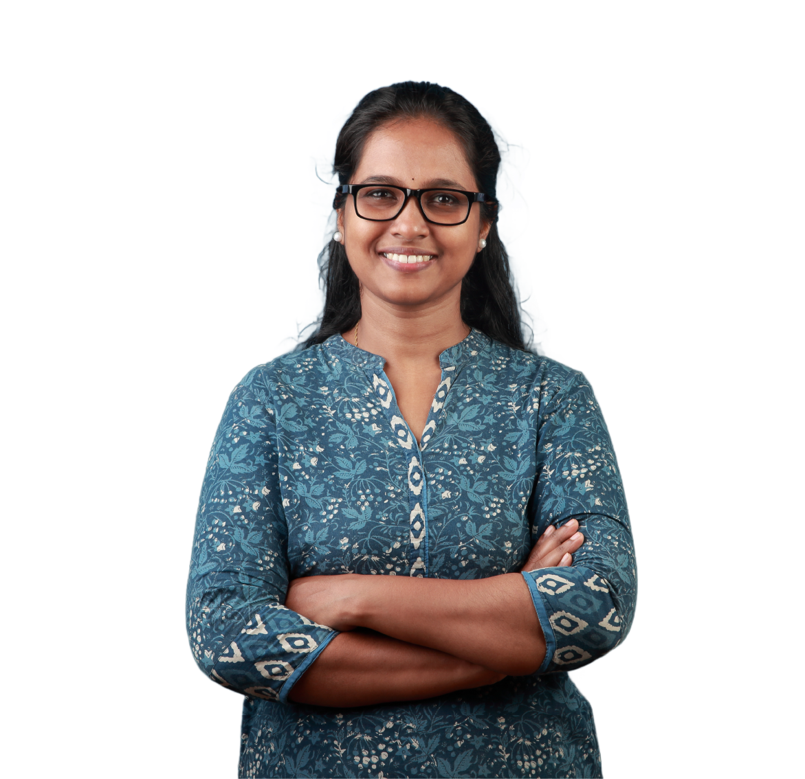 A woman wearing glasses and a blue shirt is standing with her arms crossed.