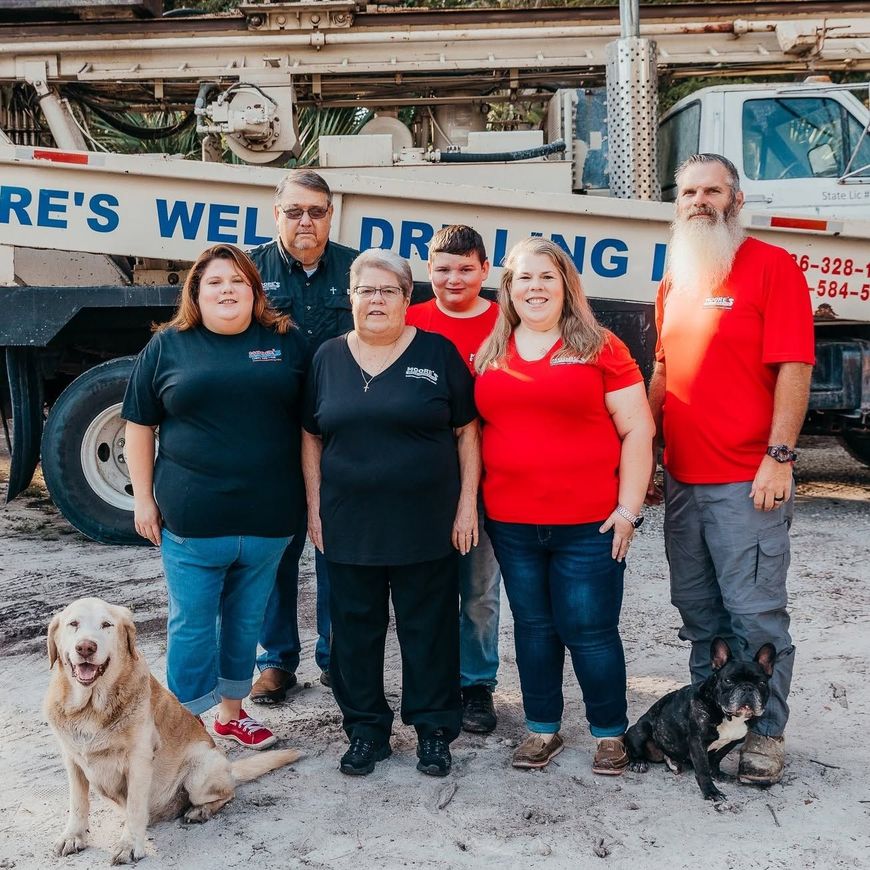 Five people standing with two dogs in front of a plumbing work truck and equipment. Five people standing with two dogs in front of a plumbing work truck and equipment.