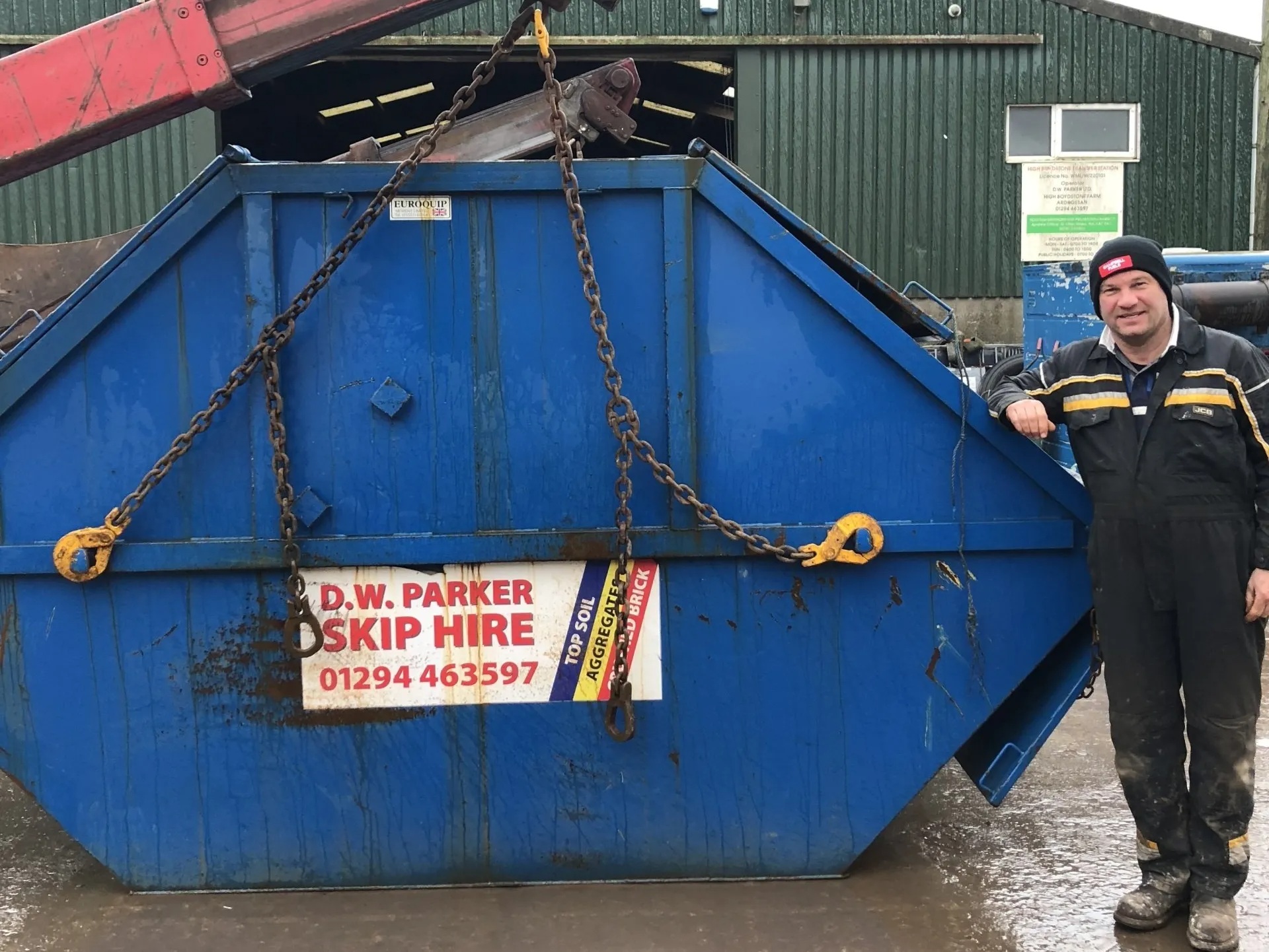 Blue skip with workman standing alongside