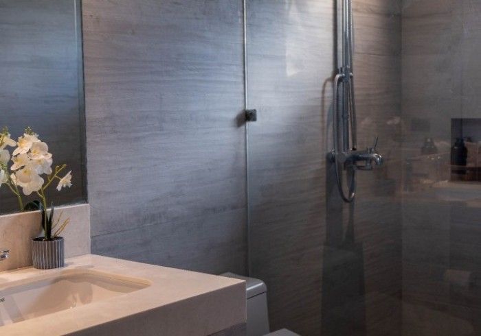 A bathroom with a sink , toilet , shower and mirror.
