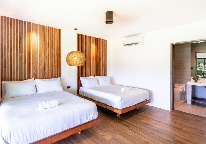 A hotel room with two beds and a bathroom.