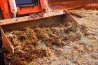 A long, narrow trench dug into dry, dirt ground in a wide-open, grassy field.