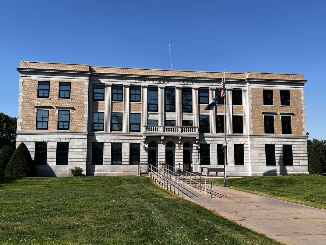 A large building with a flag in front of it.