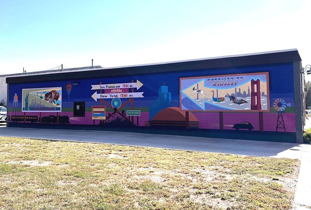 A large mural is painted on the side of a building.