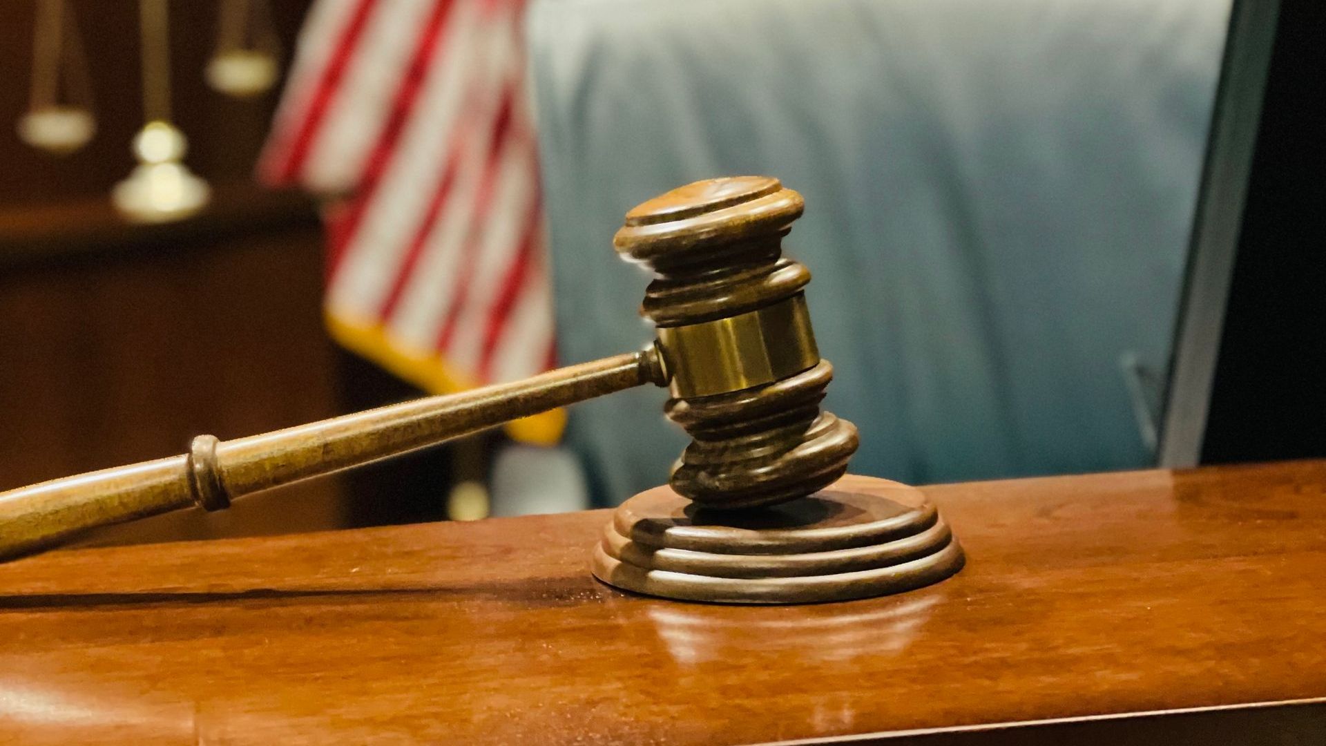 A judge 's gavel is sitting on a wooden table in a courtroom.