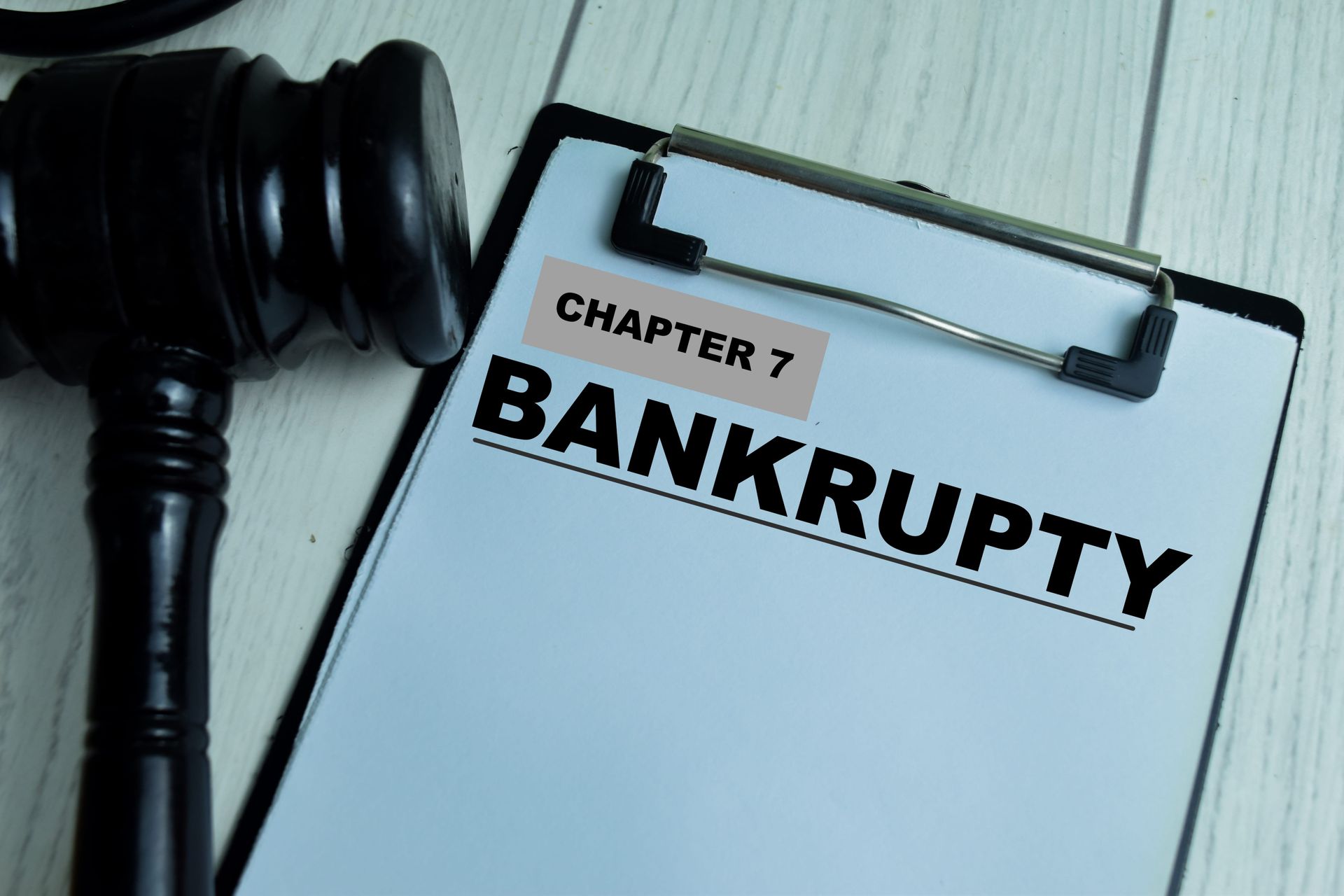 Judge’s gavel beside clipboard labeled “Chapter 7 Bankruptcy”
