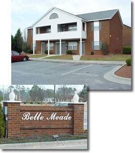 Apartment building, Belle Meade sign. Red brick exterior, parking lot, red car.