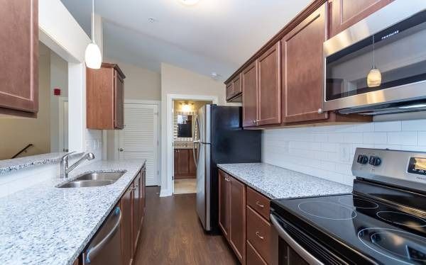 Kitchen with brown cabinets, stainless steel appliances, and granite countertops.