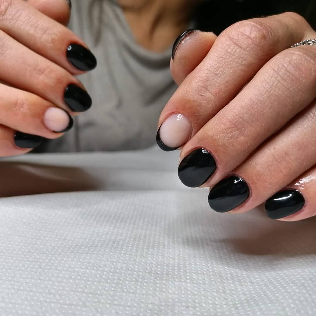 Un primo piano delle mani di una donna con le unghie nere