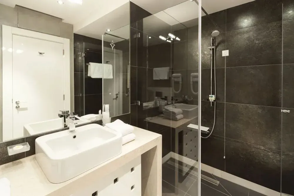A bathroom with a sink and a walk in shower