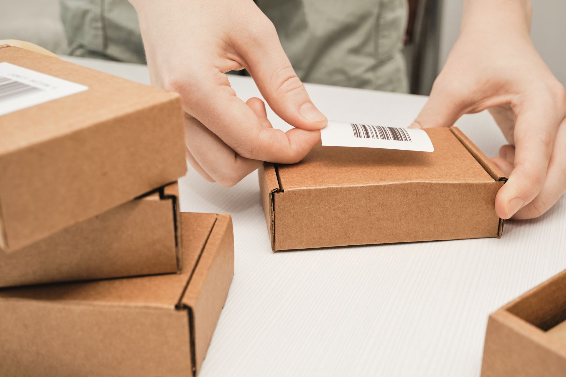 Local shipping service worker labeling a fragile package for transit.