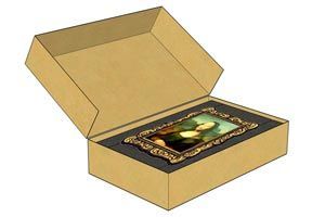 An open cardboard box containing a framed picture with a green gemstone centerpiece