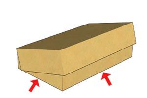 Top of a cardboard box lifting at the corners, with red arrows pointing to the bent edges.