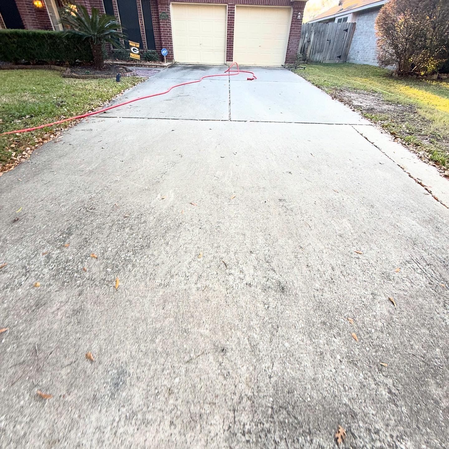 Concrete driveway leading to a two-car garage, with red marking paint near the center crack.