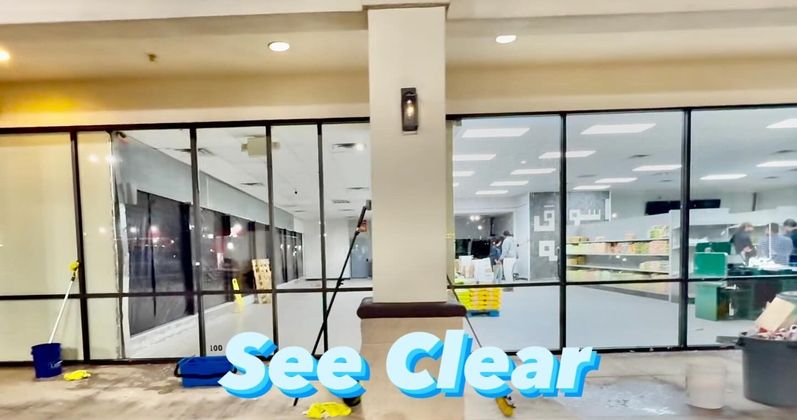 A row of windows reflects a vibrant orange sunset, with the text 